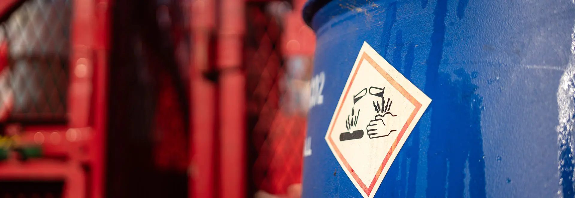 Blue barrel with corrosive warning label.